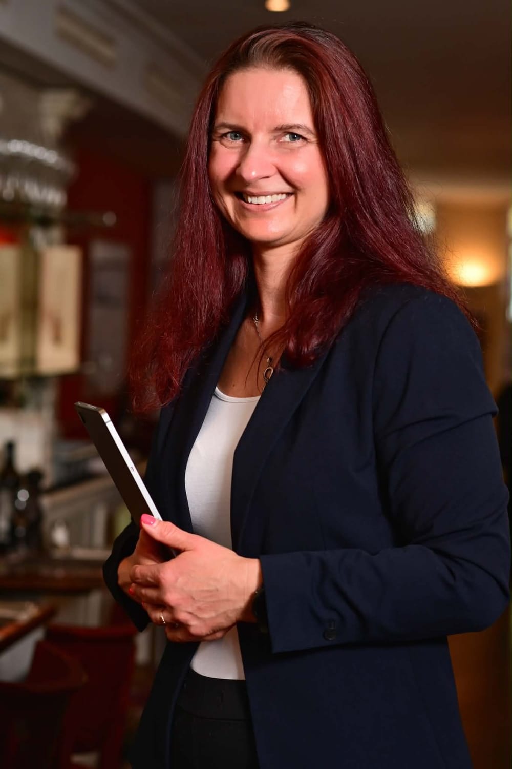 Tűhegyi Rozália mosolyogva, táblagéppel